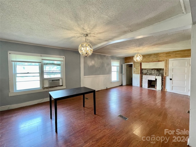 unfurnished dining area featuring a textured ceiling, wood-type flooring, and a fireplace