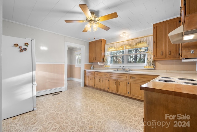 kitchen with sink, ceiling fan, ornamental molding, baseboard heating, and white fridge