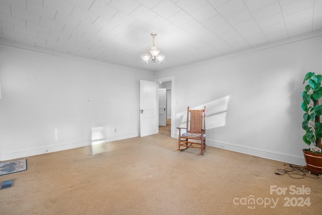 unfurnished room featuring carpet floors, an inviting chandelier, and ornamental molding