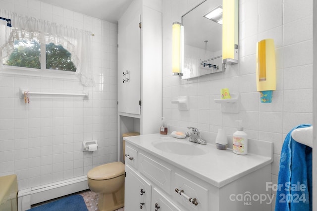 bathroom featuring vanity, baseboard heating, and tile walls