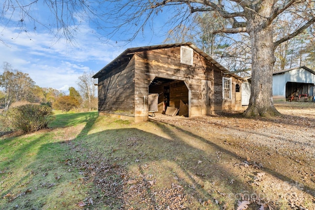 view of home's exterior with a yard and an outbuilding