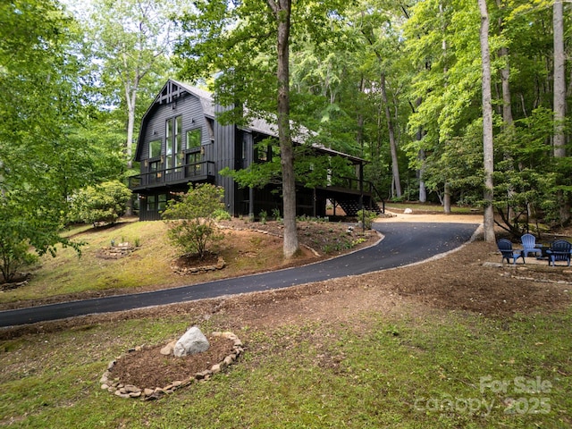 exterior space with a gambrel roof, driveway, and a deck