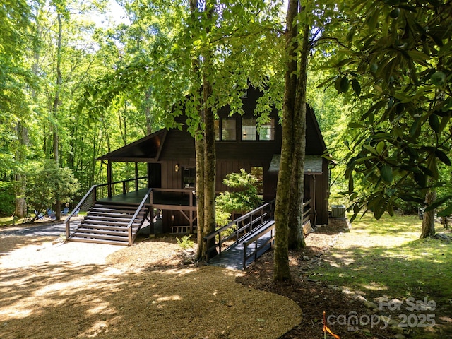 view of front of house with board and batten siding and central AC unit