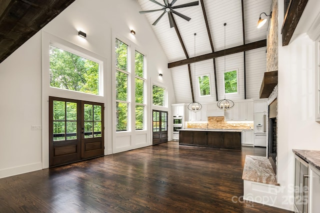 interior space with lofted ceiling with beams, french doors, and ceiling fan with notable chandelier