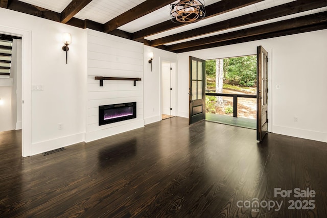 unfurnished living room with visible vents, a large fireplace, baseboards, and wood finished floors