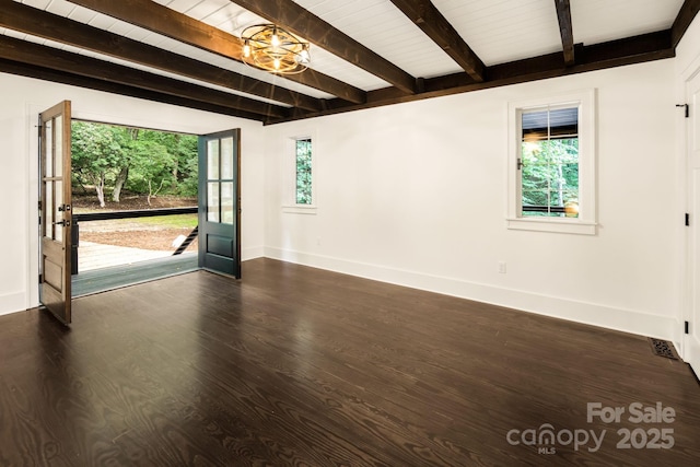 spare room featuring baseboards, plenty of natural light, beamed ceiling, and dark wood finished floors