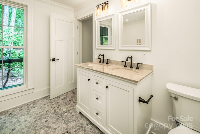 bathroom with a sink, toilet, a healthy amount of sunlight, and crown molding