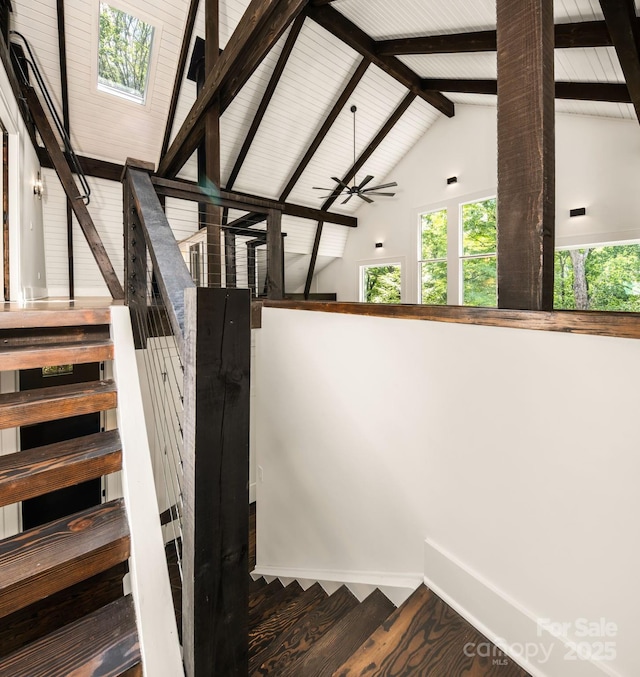 stairway featuring beamed ceiling, high vaulted ceiling, wood finished floors, baseboards, and ceiling fan