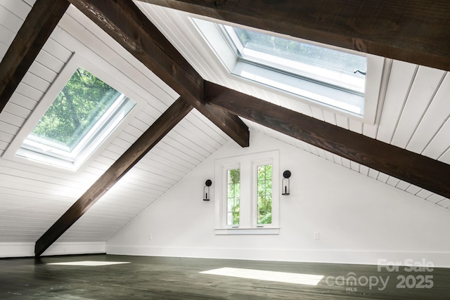 additional living space featuring lofted ceiling with skylight, baseboards, and wood finished floors