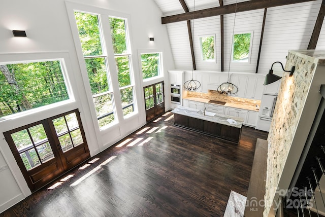 sunroom with a notable chandelier, french doors, and lofted ceiling with beams