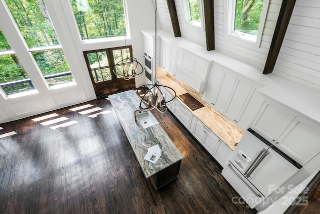 sunroom / solarium with a sink, beamed ceiling, and a notable chandelier