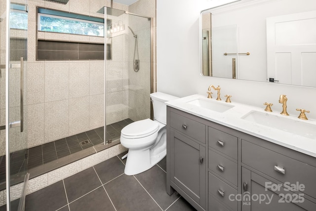 full bathroom with double vanity, a shower stall, toilet, and a sink