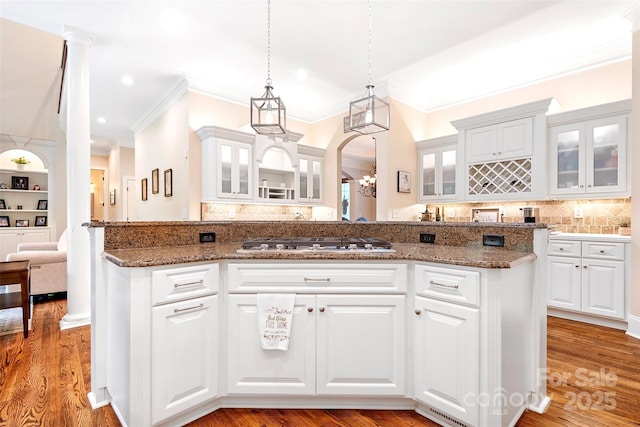 kitchen featuring white cabinetry, hanging light fixtures, dark stone countertops, and stainless steel gas stovetop