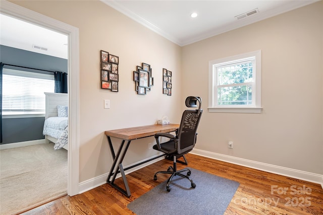 home office with crown molding, a healthy amount of sunlight, and hardwood / wood-style floors