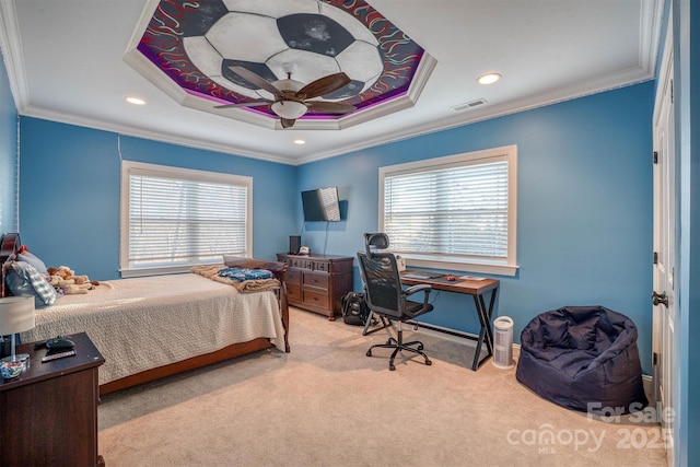 bedroom with ornamental molding, light carpet, ceiling fan, and a tray ceiling