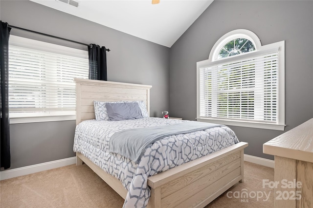 carpeted bedroom with lofted ceiling and multiple windows