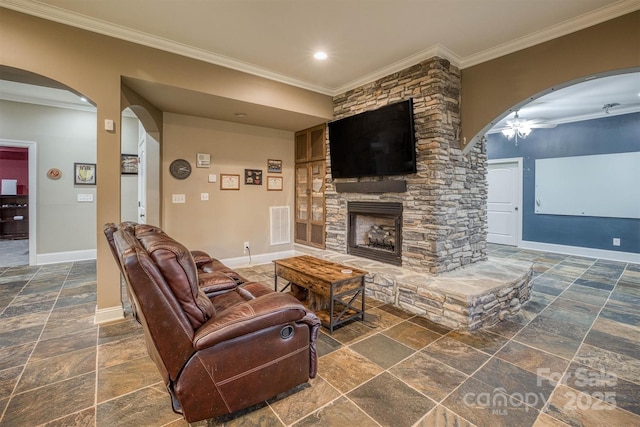 living room featuring crown molding and a stone fireplace