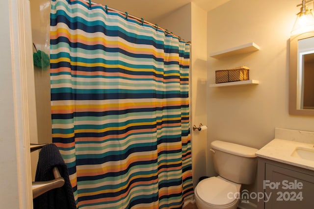 bathroom featuring a shower with curtain, vanity, and toilet