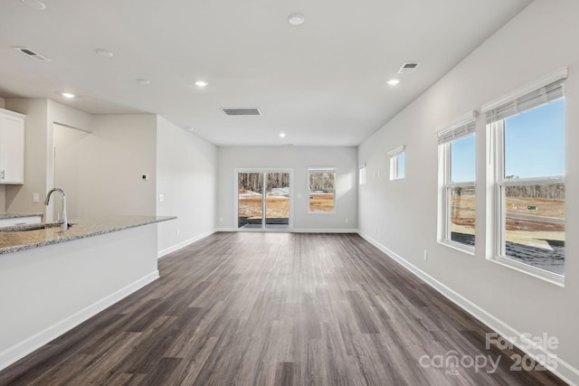 unfurnished living room with dark hardwood / wood-style flooring and sink