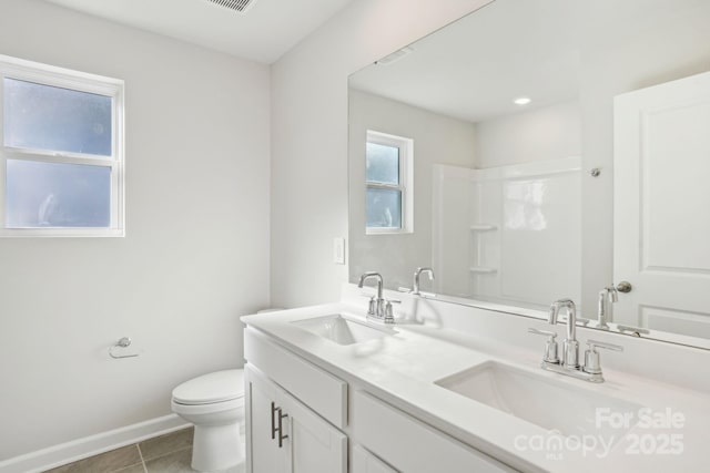 bathroom featuring toilet, vanity, tile patterned flooring, and walk in shower