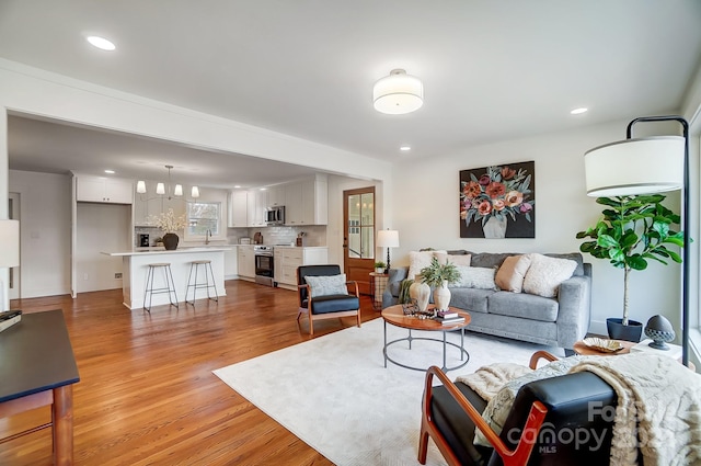 living room featuring sink and light hardwood / wood-style floors