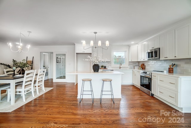 kitchen with a chandelier, appliances with stainless steel finishes, a center island, and white cabinets