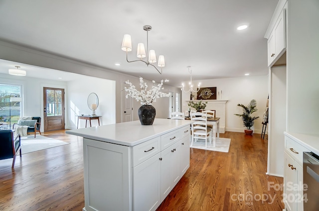 kitchen with hardwood / wood-style floors, a kitchen island, white cabinetry, and hanging light fixtures