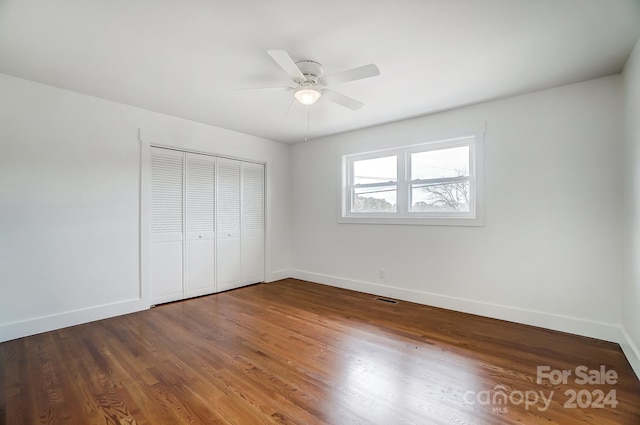 unfurnished bedroom featuring hardwood / wood-style floors, a closet, and ceiling fan