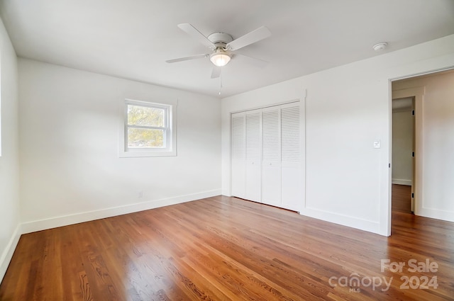 unfurnished bedroom featuring hardwood / wood-style floors, ceiling fan, and a closet