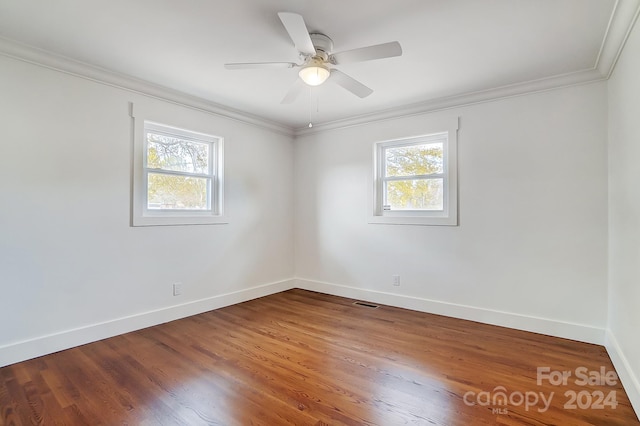 unfurnished room featuring wood-type flooring, a wealth of natural light, and crown molding