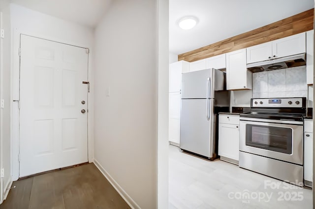 kitchen with white cabinetry, stainless steel appliances, decorative backsplash, and light wood-type flooring