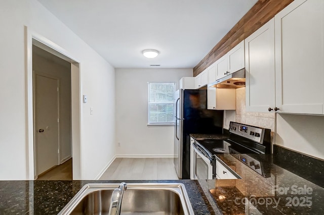 kitchen with stainless steel electric range oven, sink, dark stone countertops, and white cabinets