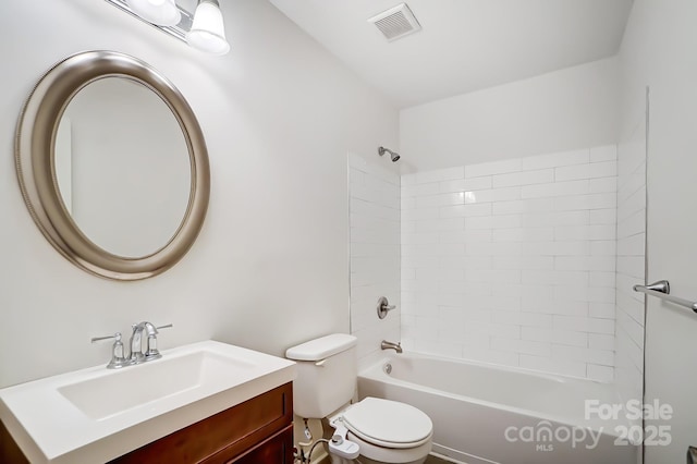 full bathroom featuring tiled shower / bath, vanity, and toilet