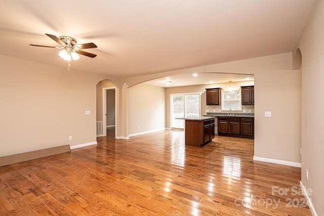 kitchen featuring dark brown cabinets, ceiling fan, sink, hardwood / wood-style flooring, and a kitchen island