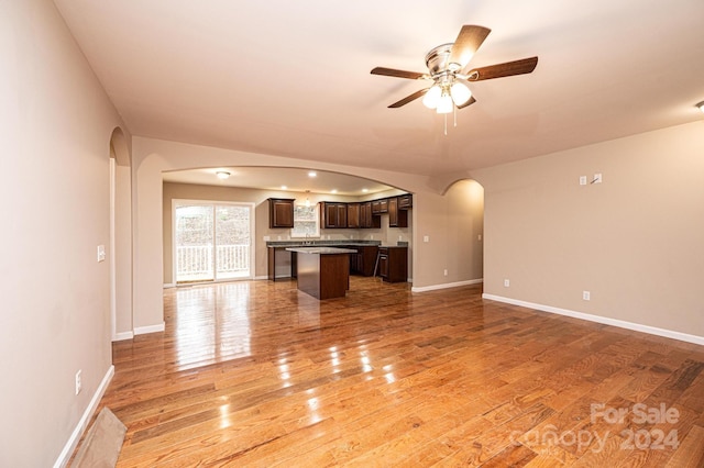 unfurnished living room with hardwood / wood-style flooring and ceiling fan