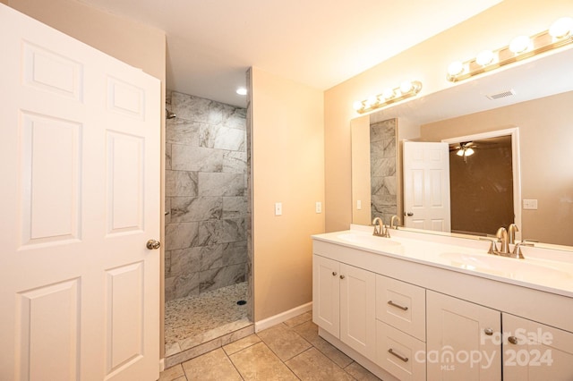 bathroom with tile patterned flooring, ceiling fan, tiled shower, and vanity