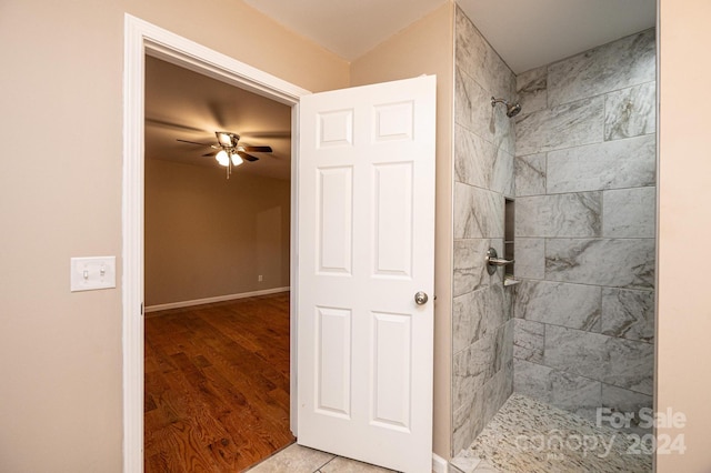 bathroom featuring a tile shower, ceiling fan, and hardwood / wood-style flooring