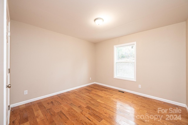 spare room with wood-type flooring