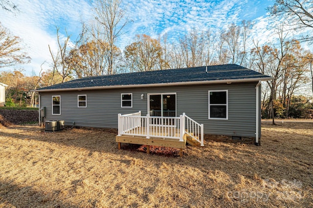 rear view of property with central AC, a deck, and a lawn