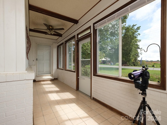 unfurnished sunroom featuring ceiling fan