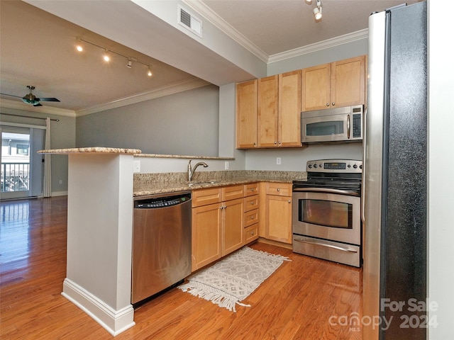 kitchen featuring light stone countertops, kitchen peninsula, appliances with stainless steel finishes, and light hardwood / wood-style flooring