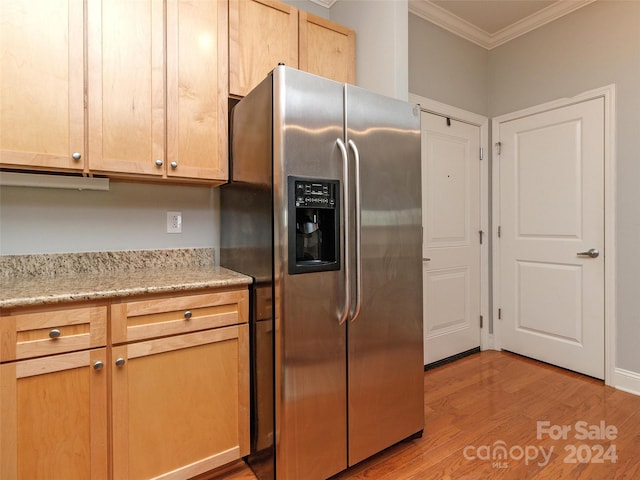 kitchen featuring stainless steel fridge, light brown cabinetry, ornamental molding, and light wood-type flooring