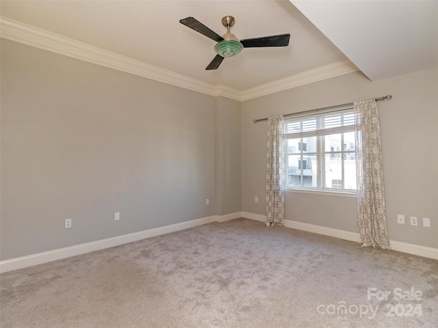 spare room featuring ceiling fan, ornamental molding, and light carpet