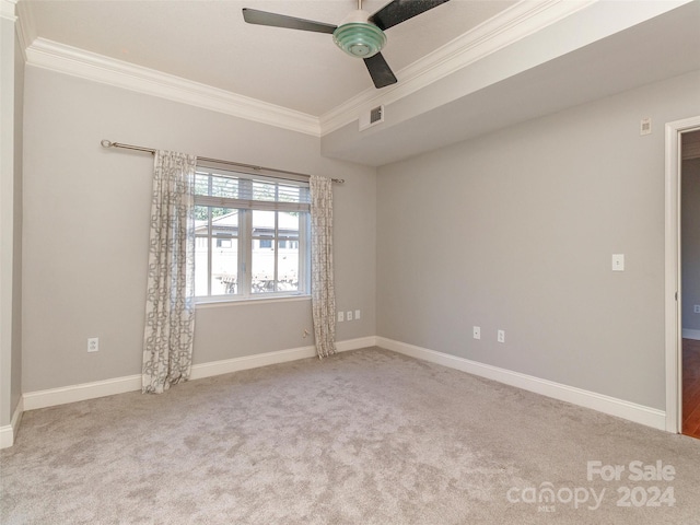 carpeted spare room with ceiling fan and ornamental molding