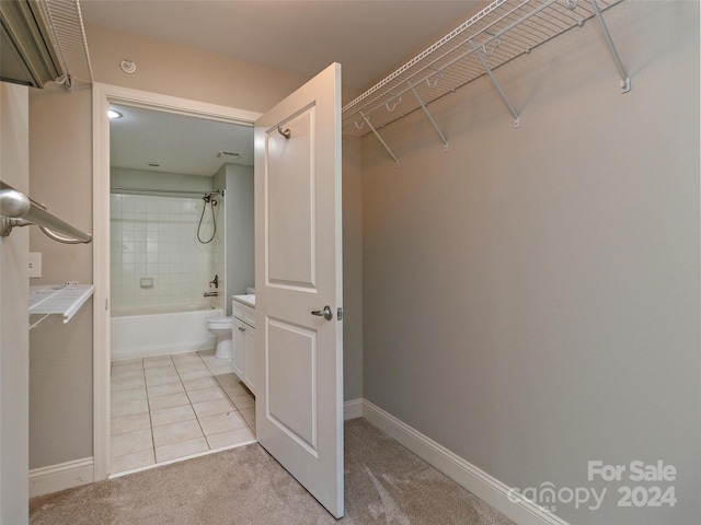 bathroom featuring tile patterned floors, toilet, and tiled shower / bath