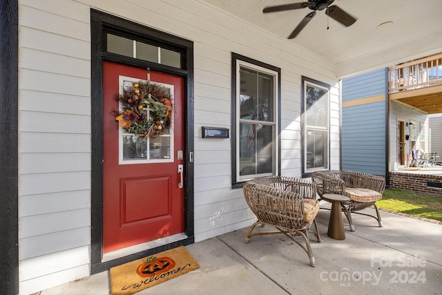 doorway to property with a porch and ceiling fan