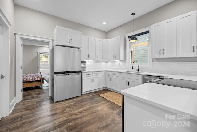 kitchen featuring stainless steel fridge, white cabinets, dark hardwood / wood-style floors, and decorative light fixtures