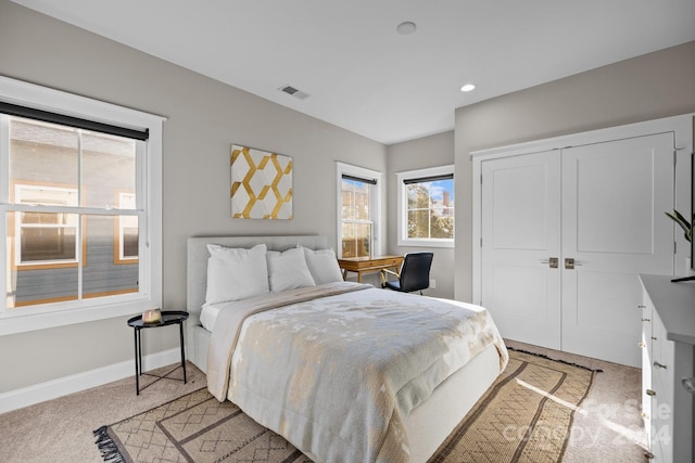 bedroom featuring light colored carpet and a closet