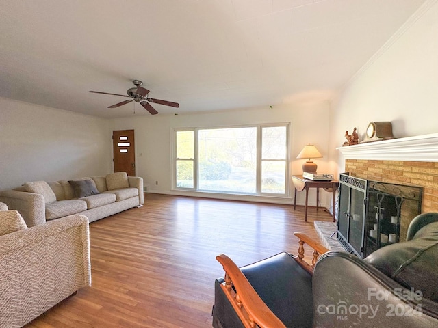 living room with ceiling fan, a fireplace, light hardwood / wood-style floors, and ornamental molding