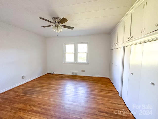 unfurnished bedroom with hardwood / wood-style floors, ceiling fan, and a closet